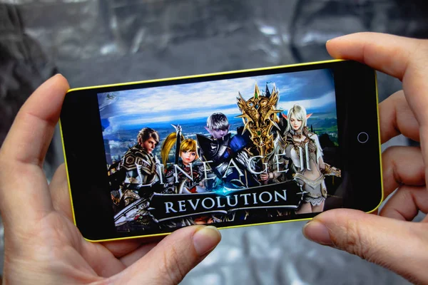 乌克兰伯迪扬斯克--2019年3月16日: 在显示屏上拿着带有血统2革命游戏的智能手机的手. — 图库照片