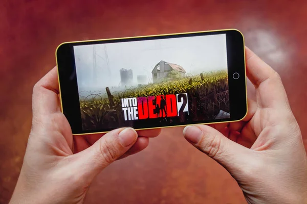 Berdyansk, Ukrayna-Mart 17, 2019: eller ekranda ölü 2 mobil oyun Into bir akıllı telefon tutarak, editoryal stok görüntü.