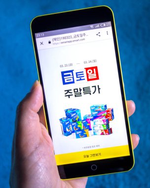 Berdyansk, Ukrayna-Mart 23, 2019: açıklayıcı editoryal, E-Mart Web sitesi homepage. E-Mart logosu telefon ekranında görünür.