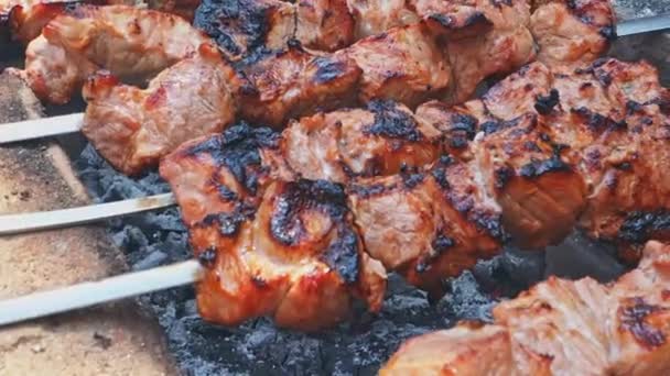 Juicy kebab pork close-up. Skewer with pieces of meat is fried on a brick grill. Homemade grill of bricks in the yard. Meat on skewers in the smoke. — Stock Video