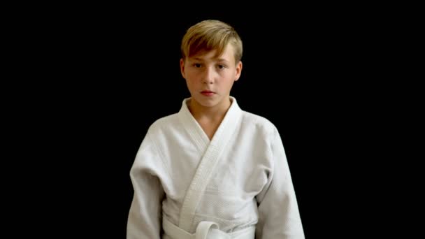 A Young Athlete In A White Kimono Stands On A Dark Background