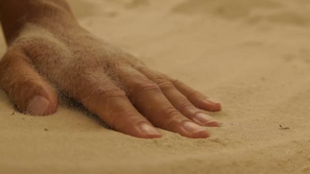 Trockener Meeressand auf einer Frauenhand — Stockvideo