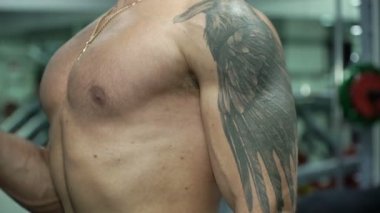 Atletik güçlü adam bir halter parlak bir spor salonunda kaldırdı.