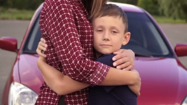 Menino Abraçou Sua Mãe Contra Carro Vermelho — Vídeo de Stock