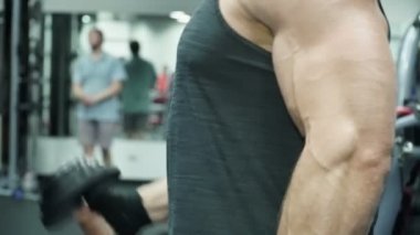 Atletik güçlü adam bir halter parlak bir spor salonunda kaldırdı.