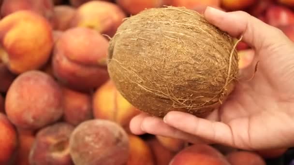 Кокос Женской Руке Фоне Свежих Персиков — стоковое видео