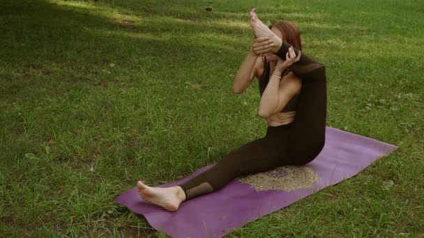 Chica joven haciendo yoga en el parque — Vídeo de stock