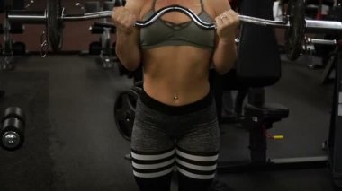 Kız bir halter ile yapıyor.