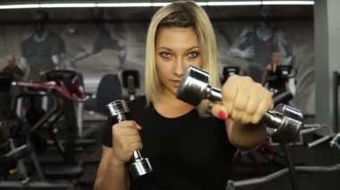 Kız ellerinde dumbbells ile yapıyor