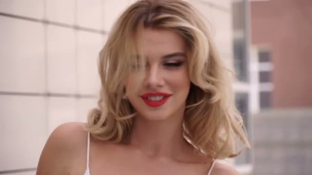 Retrato de uma bela menina feliz sorridente sexy com grandes lábios cheios com cabelo loiro — Vídeo de Stock