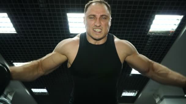 Atlético joven masculino hace ejercicios de mancuerna en el gimnasio — Vídeos de Stock