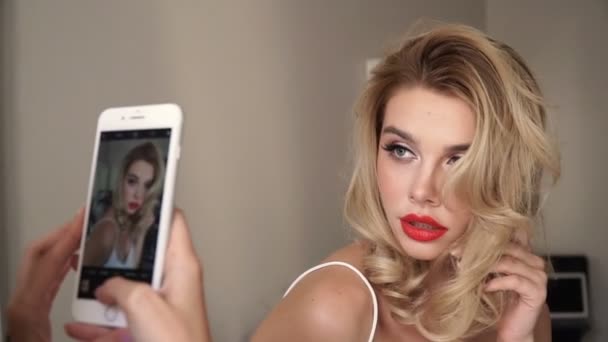 Giovane donna bionda bianca posa mentre il suo amico scatta una foto sul suo telefono — Video Stock