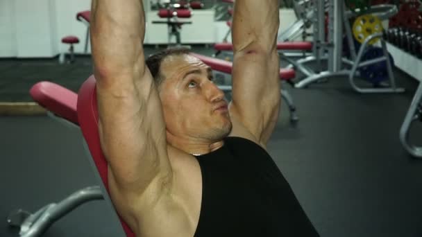 Сильный человек поднимает тяжелые тяжести над головой в спортзале . — стоковое видео