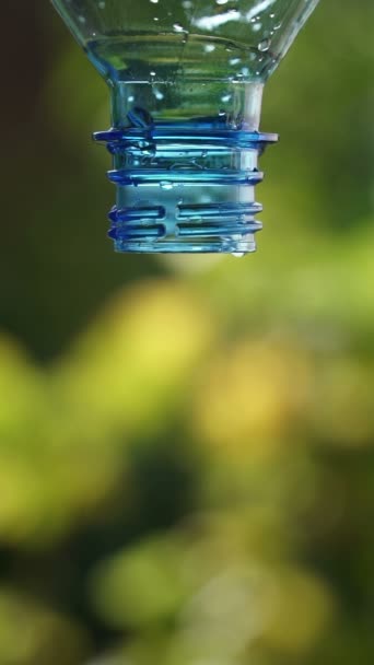 Deje caer una gota de agua de una botella de plástico vacía . — Vídeo de stock