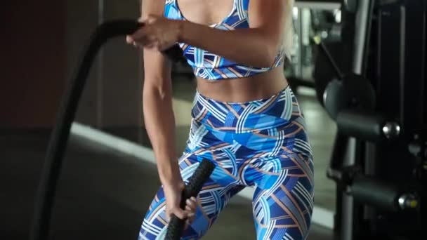Спортивний жінка активно в тренажерний зал вправи бою мотузками під час її хрест фітнес-тренування. Повільний рух — стокове відео