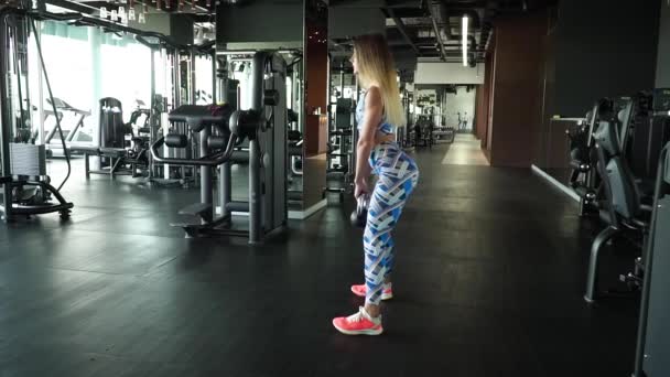 スポーティな女の子は、ジムで体重を持ち上げる — ストック動画