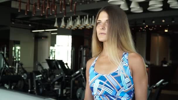 Attraktiva flicka kör på löpbandet i gymmet. Full face porträtt — Stockvideo