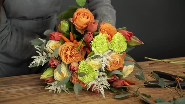 Çiçekçi bir buket çiçek satışı için hazırlar. — Stok video