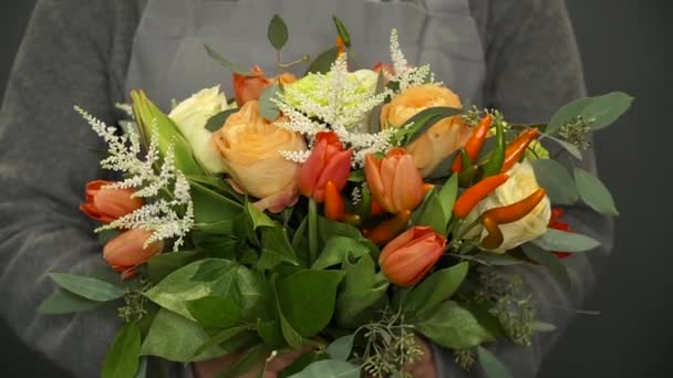 Una mujer sosteniendo un florista en sus manos un hermoso ramo — Vídeos de Stock