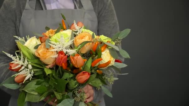 Een vrouw met een bloemist in haar handen een mooie boeket — Stockvideo
