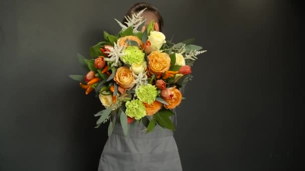 Una donna che tiene un fioraio tra le mani un bellissimo bouquet — Video Stock