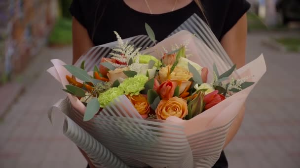 Girl holding a bouquet of fresh flowers in her hands — Stock Video