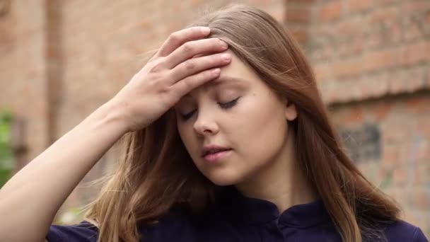 レンガ壁の背景にカメラにポーズ青いドレスの少女 — ストック動画