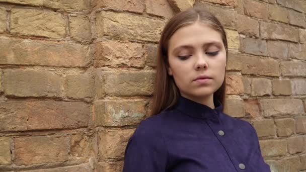 Dziewczyna Niebieskiej Sukience Pozowanie Kamery Tle Ściany Cegła — Wideo stockowe