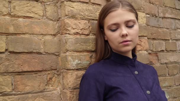 Mädchen Blauen Kleid Posiert Vor Backsteinmauer Hintergrund Vor Der Kamera — Stockvideo