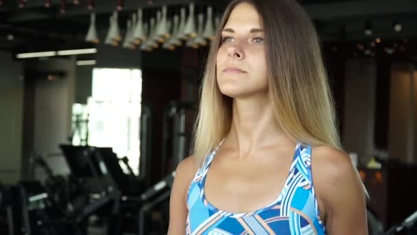 Attraktiva flicka kör på löpbandet i gymmet. Full face porträtt — Stockvideo