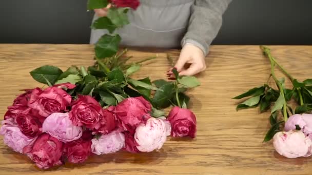 Mujer florista prepara flores para la venta — Vídeo de stock