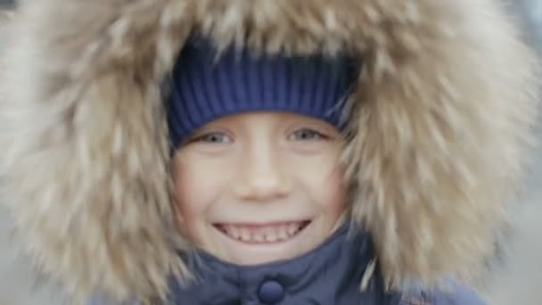 Portrait of a boy in winter jacket with hood on his head — Stock Video