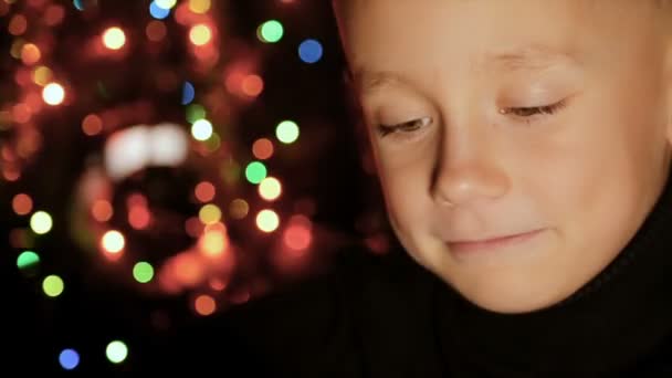Portré egy gyermek, a háttérben a karácsonyi fények — Stock videók