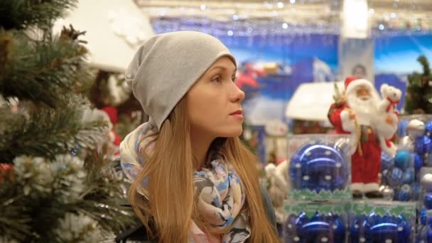 Porträt eines Mädchens im Supermarkt vor dem Hintergrund der Weihnachtsdekoration — Stockvideo