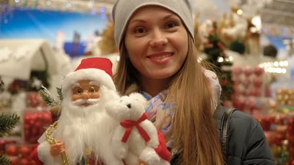 Ritratto di una ragazza in un supermercato sullo sfondo di decorazioni natalizie — Video Stock