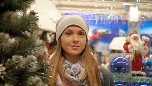 Портрет девушки в супермаркете на фоне рождественских украшений — стоковое видео