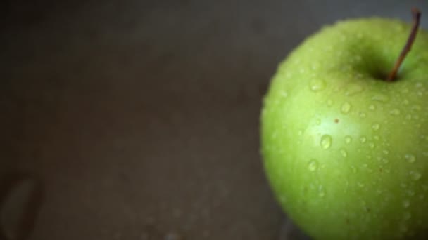 Περιστροφή πράσινου μήλου με σταγόνες νερού — Αρχείο Βίντεο