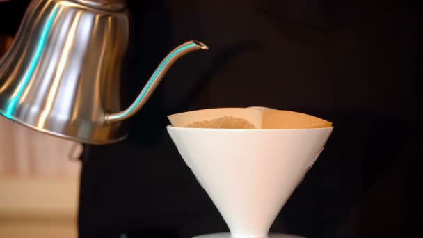 Barista versa acqua calda attraverso un filtro di carta in una brocca di caffè — Video Stock