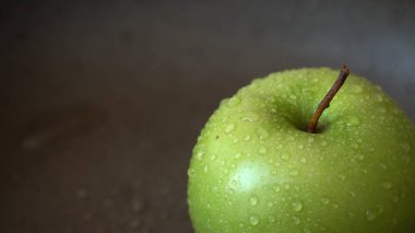 Yeşil elma dönüyor. Yakın çekim. Tam kamera görüntüsü.