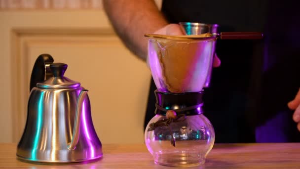 Barista fait du café, verse de l'eau chaude à travers un filtre dans une fiole en verre — Video