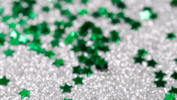 Sprankelende glitter in de vorm van een ster. Close-up op een zilveren achtergrond — Stockvideo