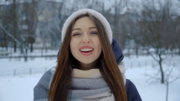 따뜻한 겨울 옷 겨울에 공원에서 웃는 젊은 여자의 초상화. — 비디오