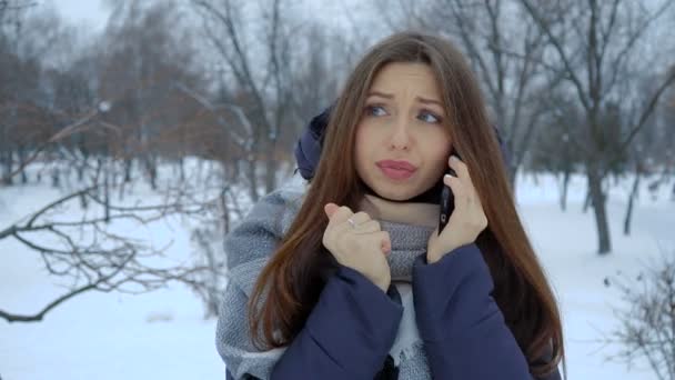 Ella calienta sus manos en invierno de pie en la nieve. Vídeo completo hd — Vídeos de Stock