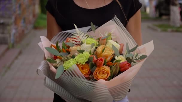 Chica sosteniendo un ramo de flores frescas en sus manos — Vídeos de Stock