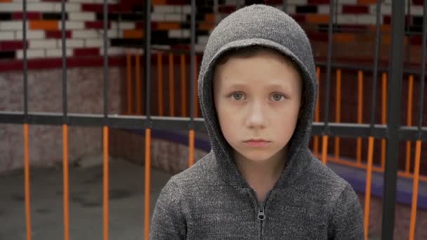 Retrato de un niño cerca de la valla metálica — Vídeos de Stock