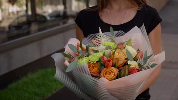 Menina segurando um buquê de flores frescas em suas mãos — Vídeo de Stock