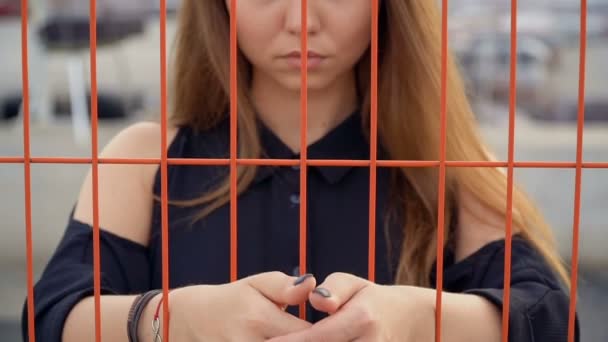 Frustriertes Mädchen legte ihre Hände auf das Gitter, Fechten — Stockvideo