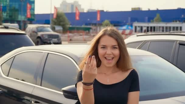 Chica feliz con llave en la mano desde el coche nuevo — Vídeos de Stock