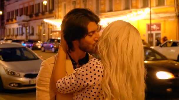 Romantikus pár ölelgetés és megcsókolta a háttérben a lámpák és az ablak jelenik meg az éjszakai város. — Stock videók