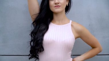 İnce kız gri bir duvara poz